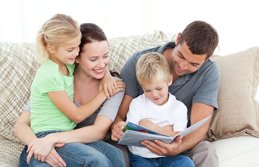 Family reading a book together.