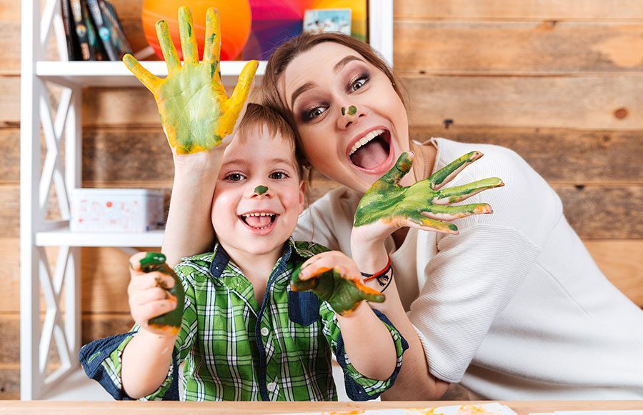 A mother and son playing with finger paint.