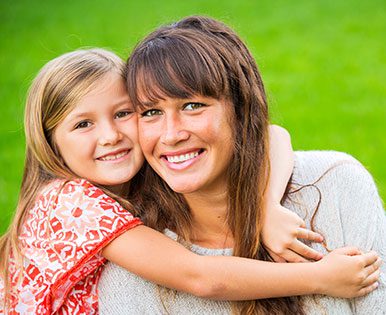 A mother and daughter smiling for the camera.
