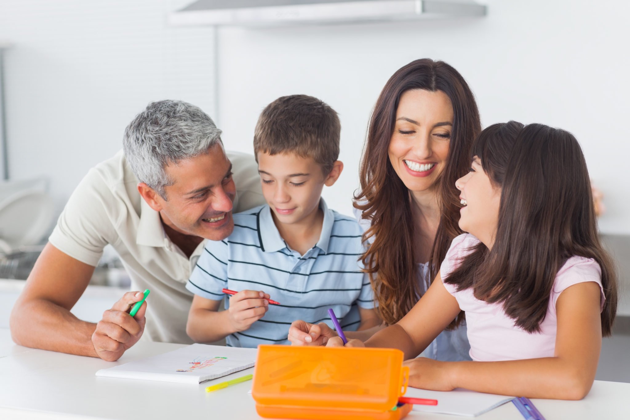Smiling family drawing together in kitchen