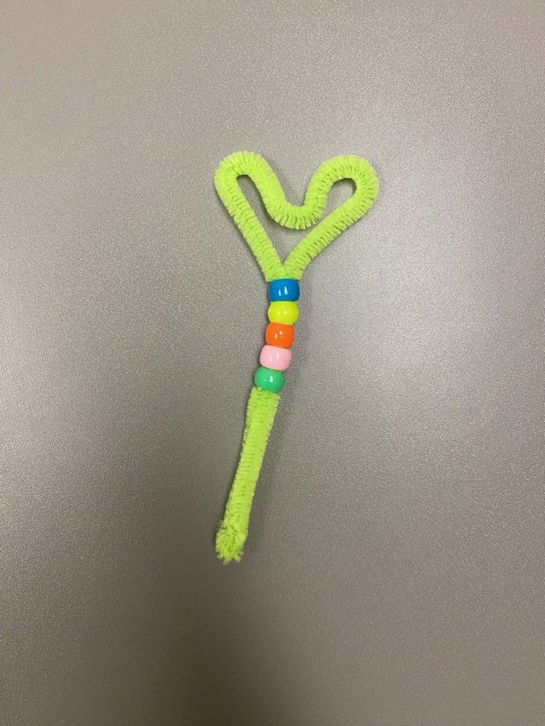 Craft. Green Pipe Cleaner wand with beads and heart-shaped end.