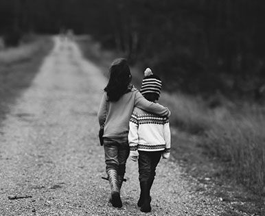 Children walking together on dirt path.