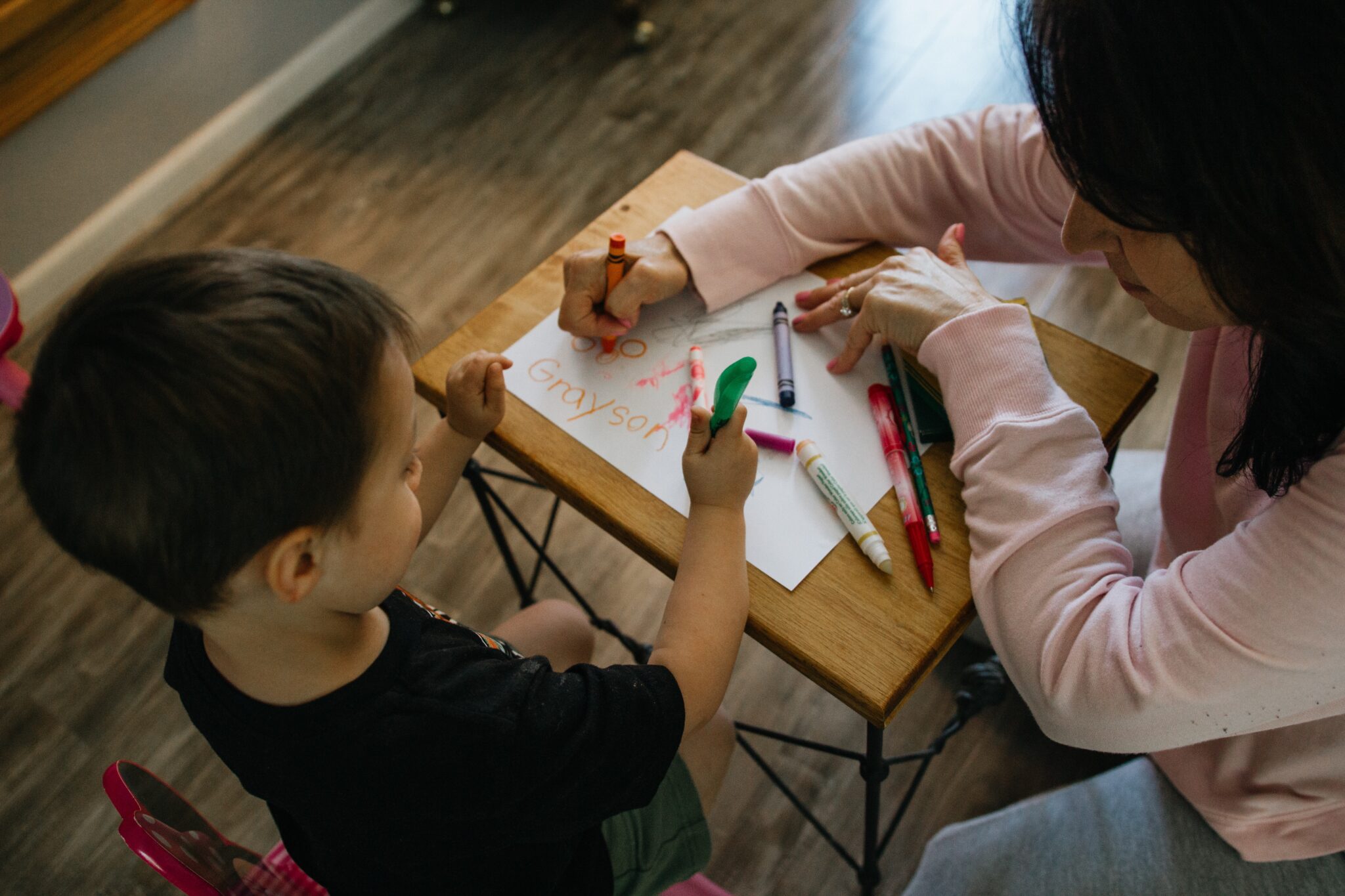 A mother and son drawing on paper.